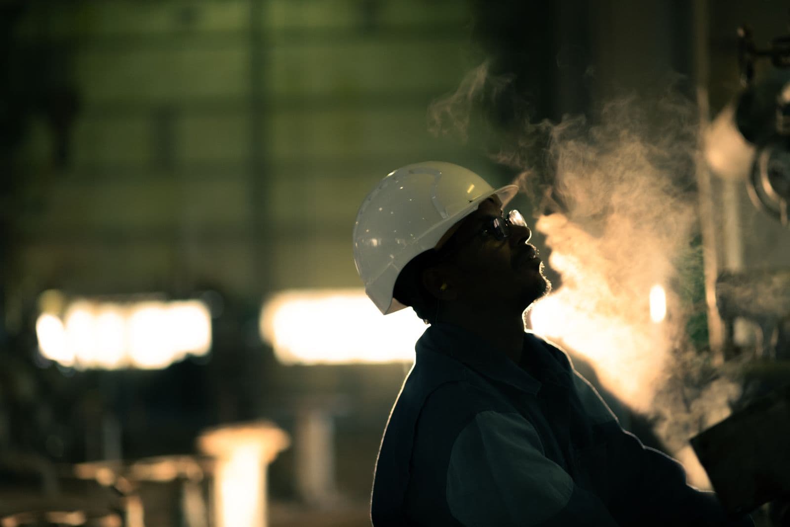 Engineer inspecting industrial equipment in steam