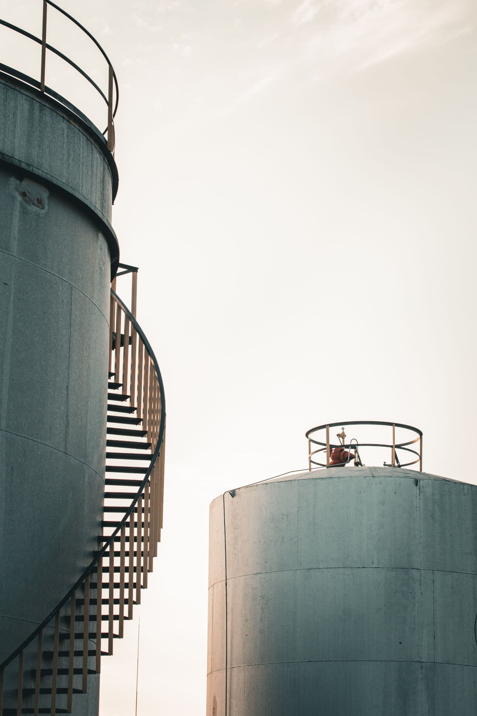Welded steel tanks with spiral staircase at sunrise